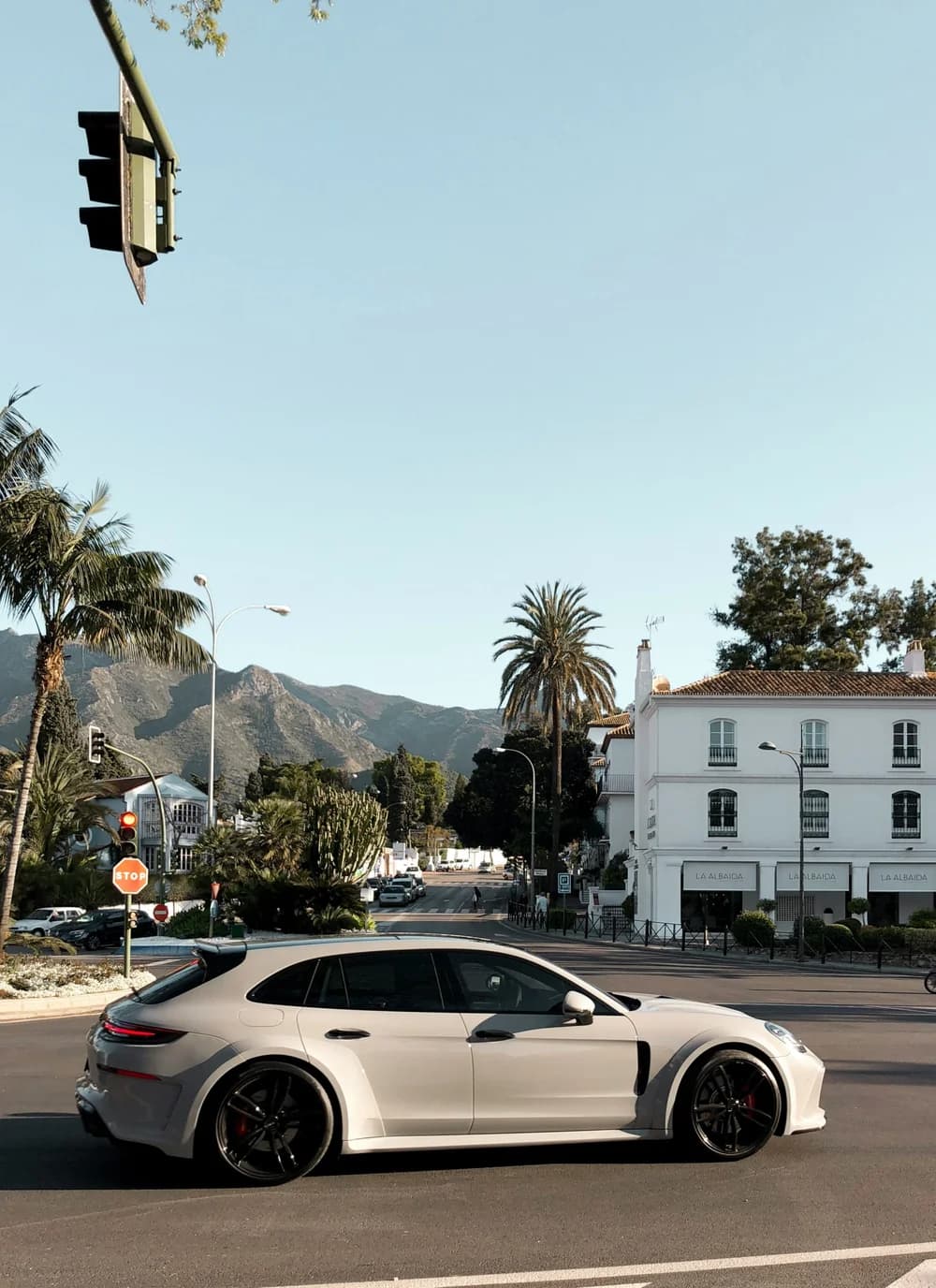 Straatbeeld van Marbella met palmen en bergen op de achtergrond